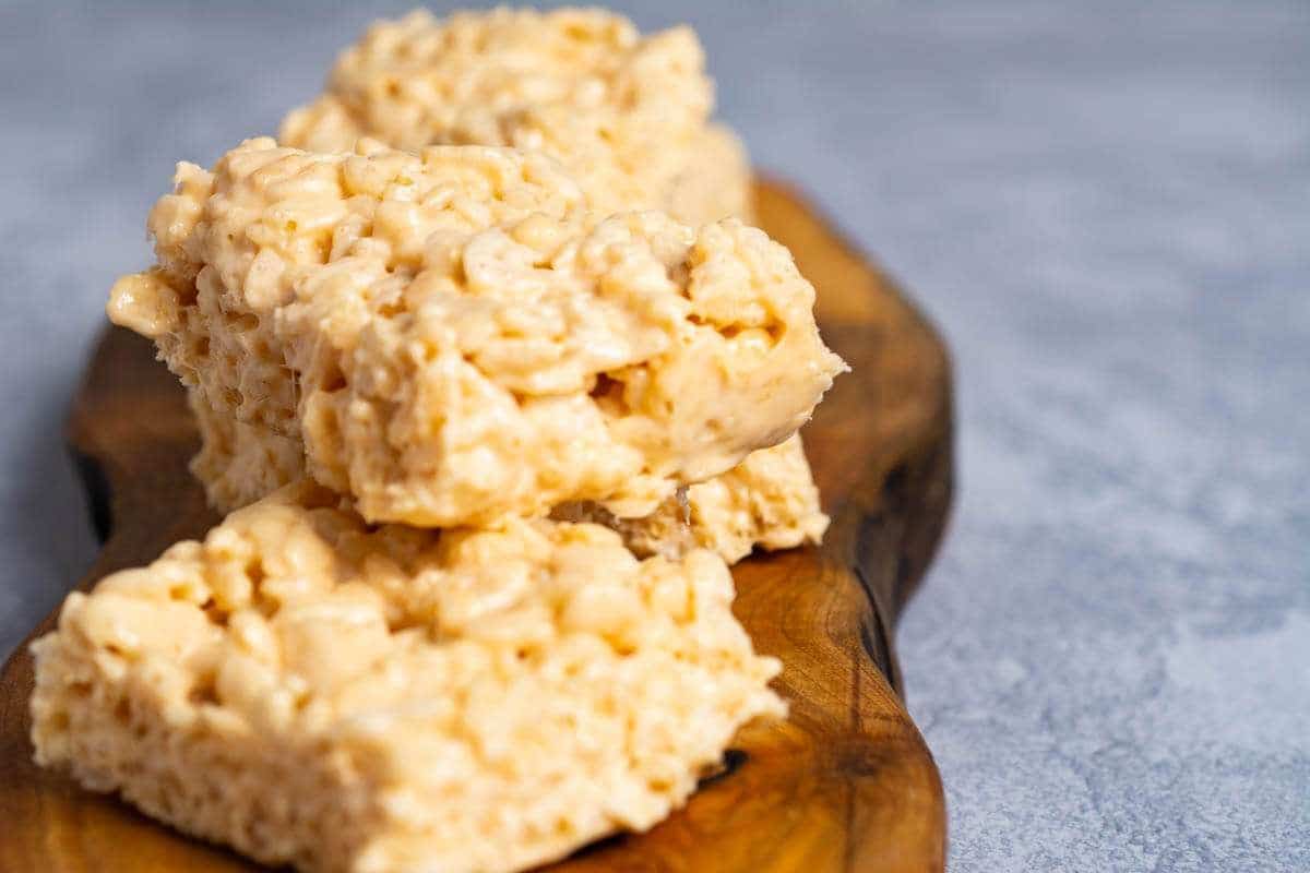 Butterscotch Rice Krispie Treats on a wooden decorative board.