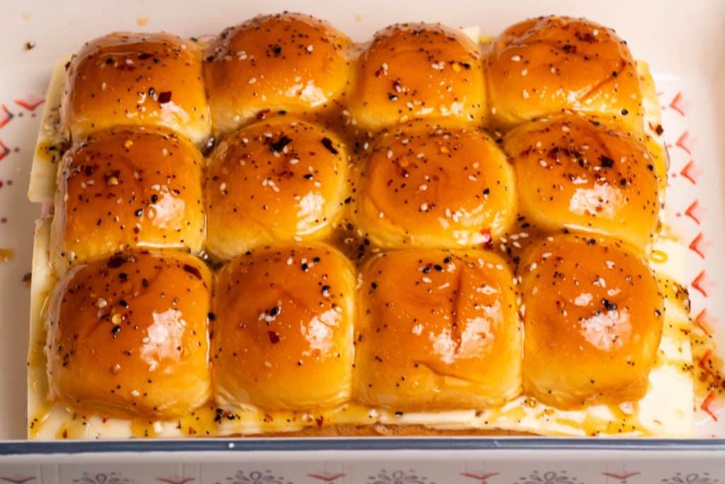 Ham and cheese sliders with brown sugar in a rectangular cake pan.