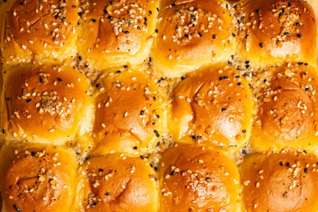 An overhead image of turkey sliders Hawaiian rolls with a sesame seed topping.