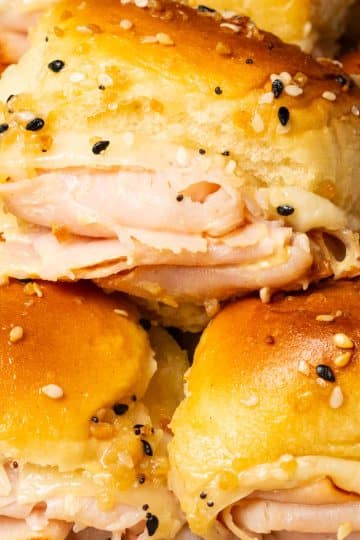 A few turkey slider on Hawaiian rolls stacked on top of each other.