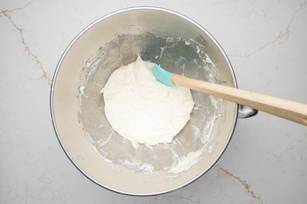 A mixing bowl with a cream cheese and powdered sugar mixture.