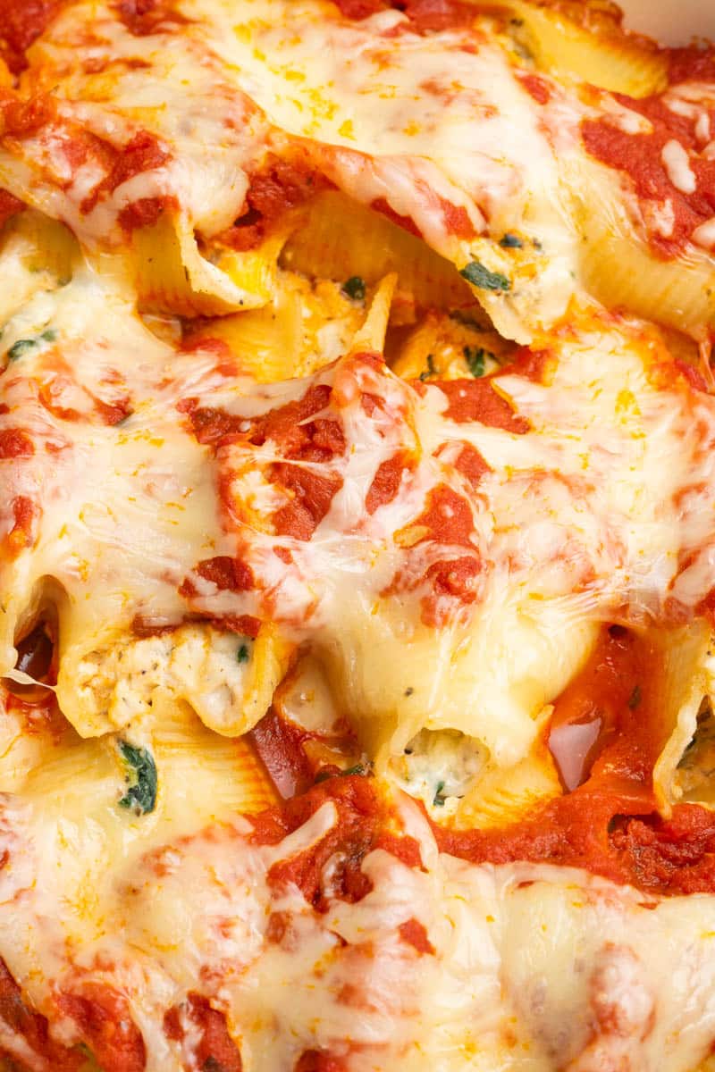 Close up photo of stuffed shells with ricotta cheese and spinach.