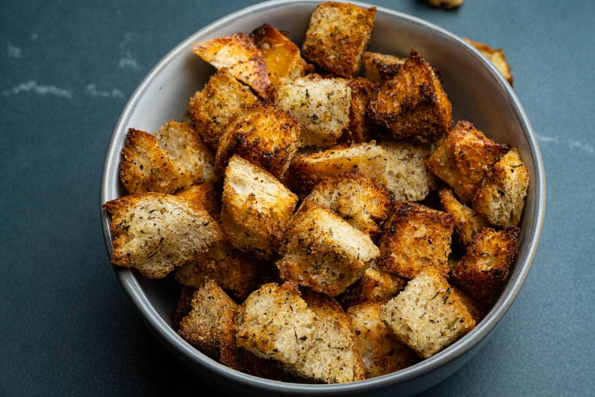 A bowl of air fryer croutons in a round bowl on a table.