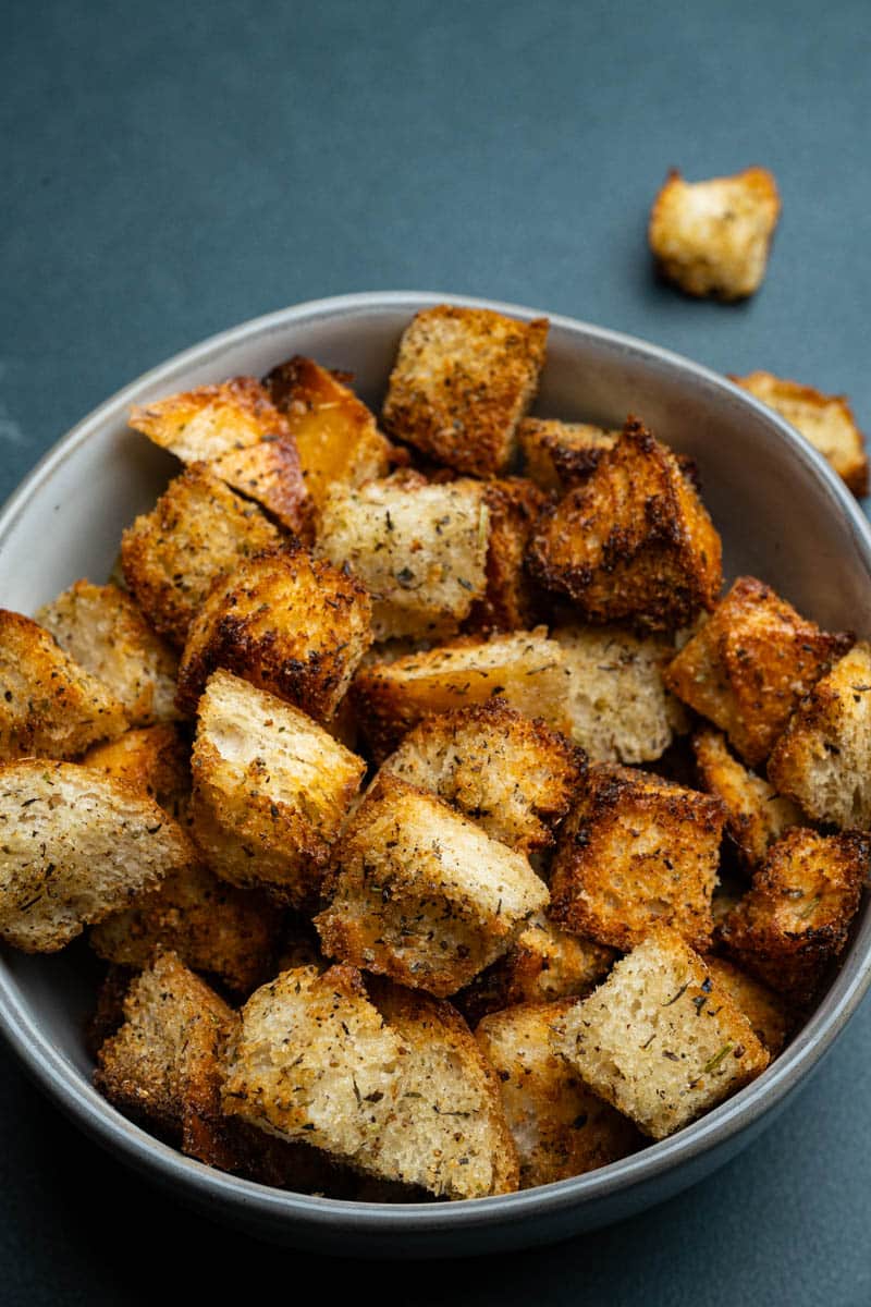 A bowl of air fryer croutons in a round bowl on a table.