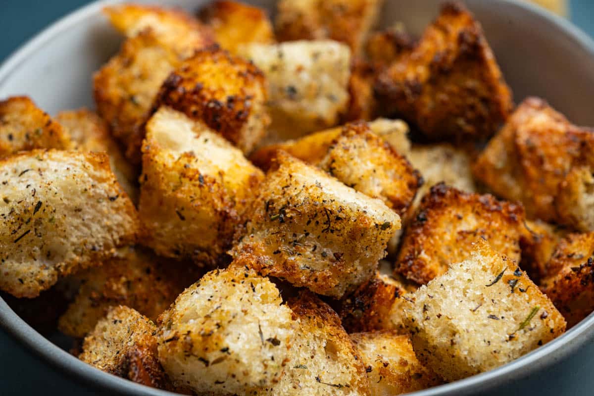 A bowl of air fryer croutons in a round bowl on a table.